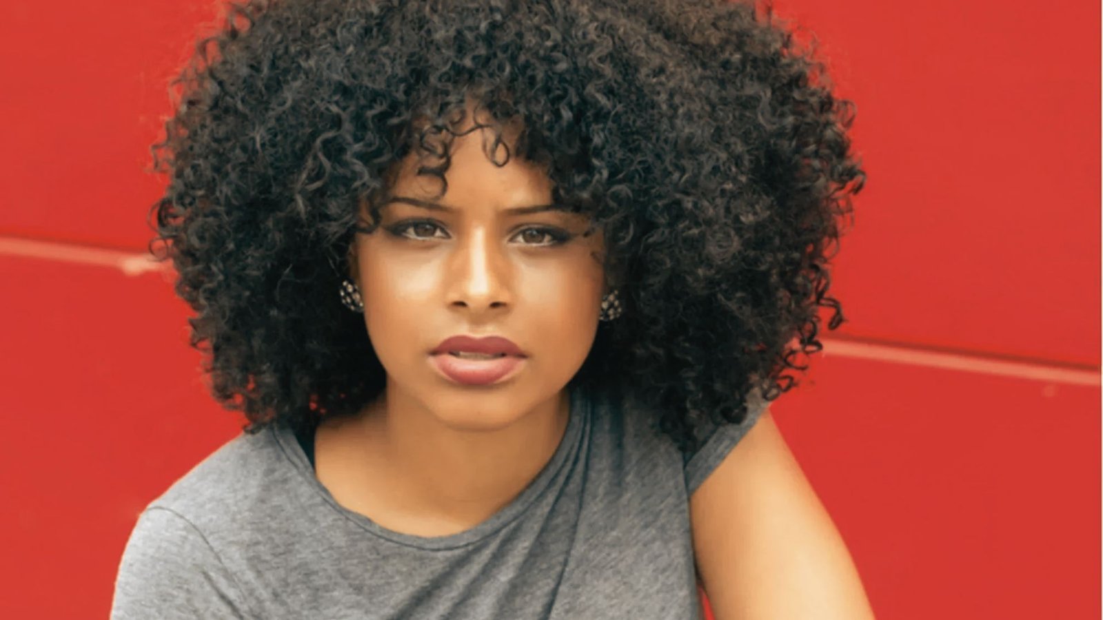 A woman with curly hair, styled for a defined and frizz-free look