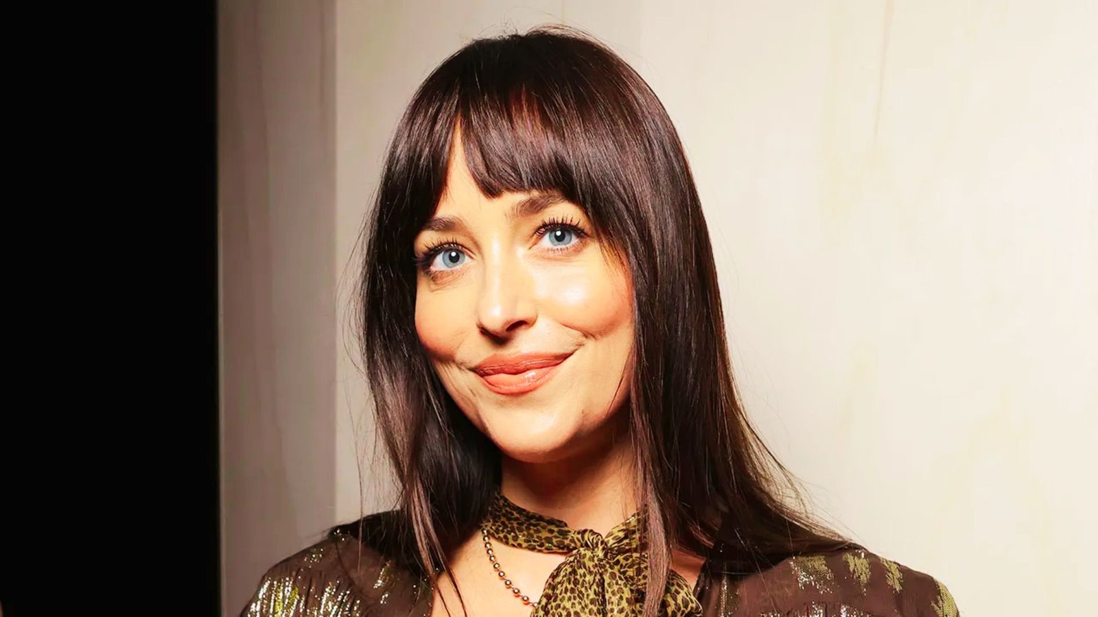 A woman with long, straight hair featuring a soft curtain fringe, highlighting a popular bang style.
