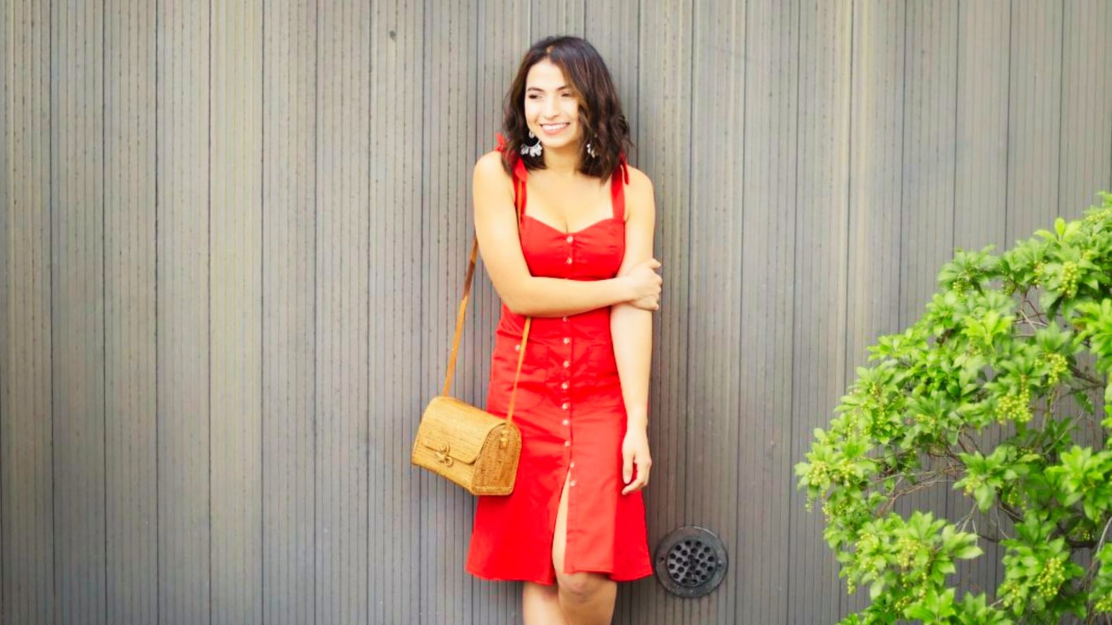 A woman in a red midi dress poses for a photo, showcasing a stylish and effortless look for stay-at-home moms.