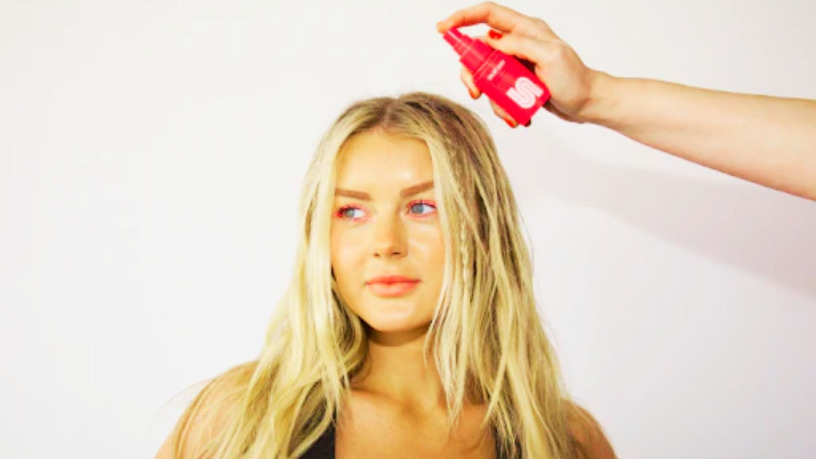 A woman is having her hair styled, focusing on her hair's texture and the stylist's technique.
