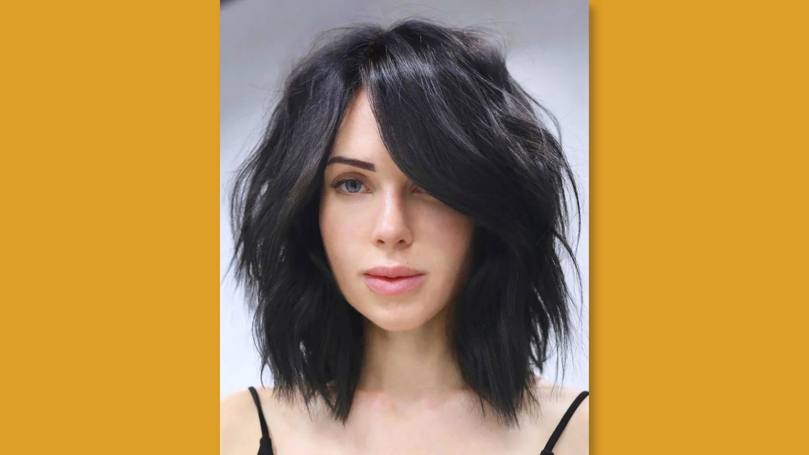 Layered low maintenance medium length shag with textured side-swept bangs on black hair for round face