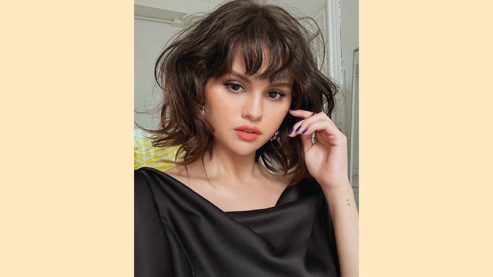 Tousled wavy dark brown lob with wispy curtain bangs and soft choppy layer