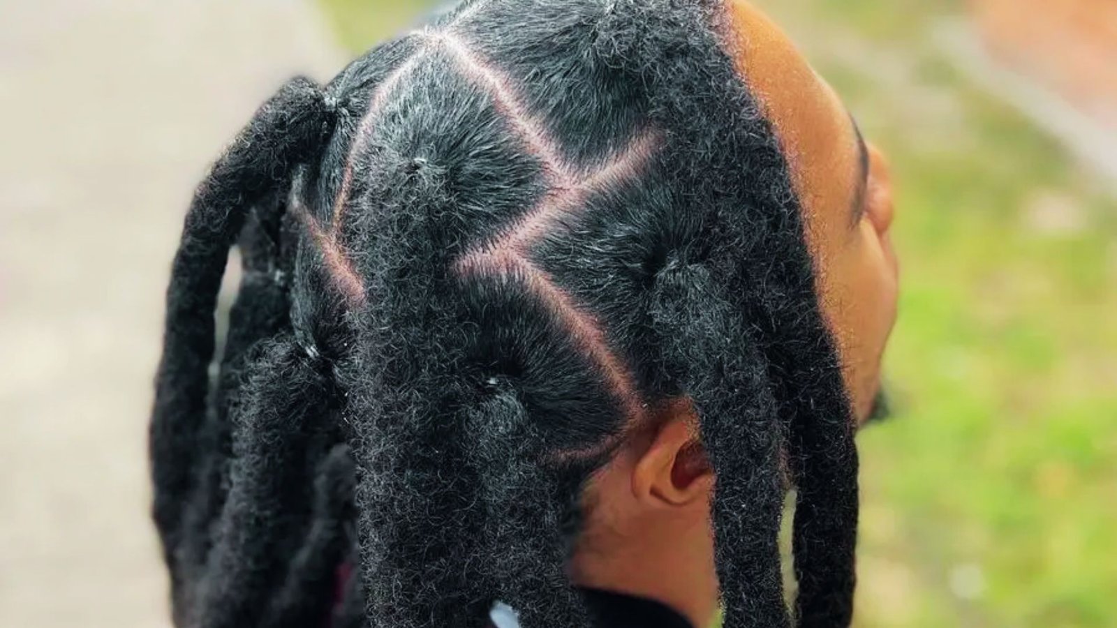 A man with mid-length thick dreadlocks styled in wicks, showcasing a new and textured hairstyle.