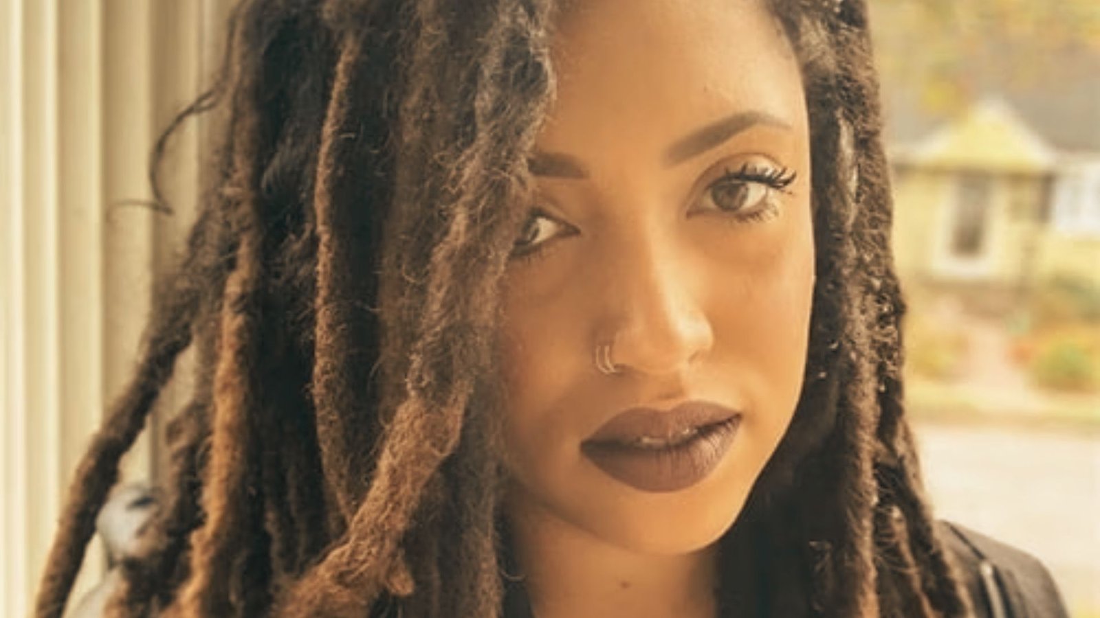 A woman with braids styled in a braided roots wicks hairstyle.
