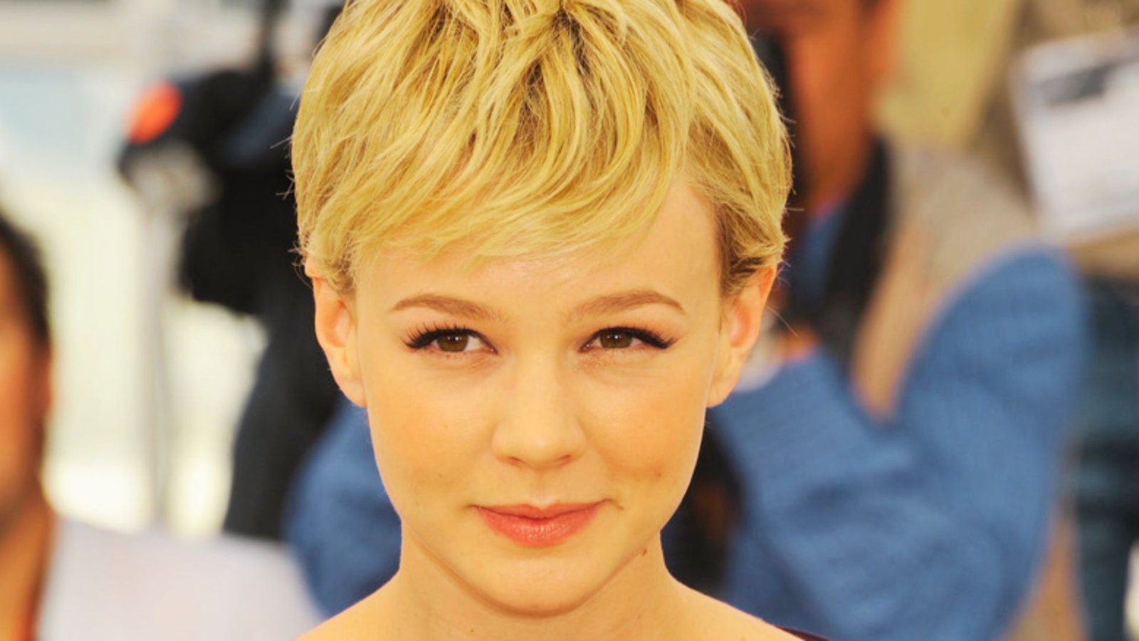 A woman with a tousled pixie cut and short blonde hair