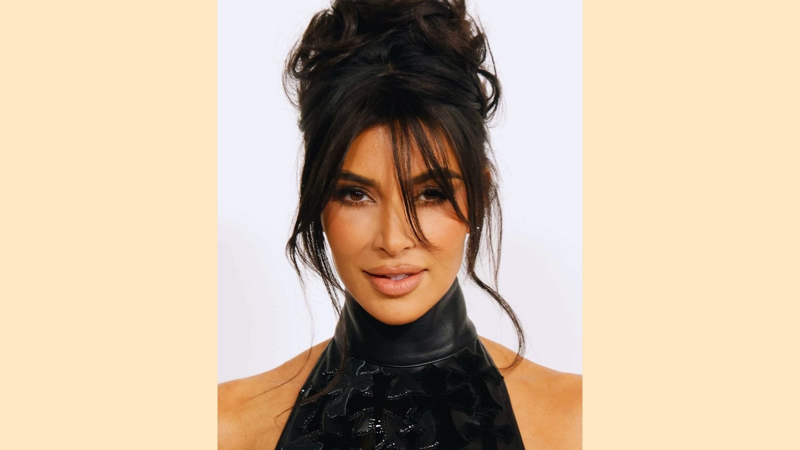 High messy bun updo with wispy piecey curtain bangs and face-framing tendrils on dark brown hair