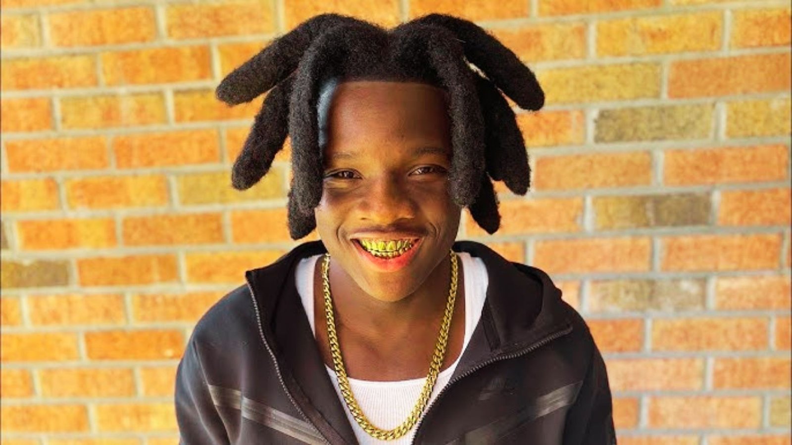 A young man with freeform wicks hairstyle and a gold chain,