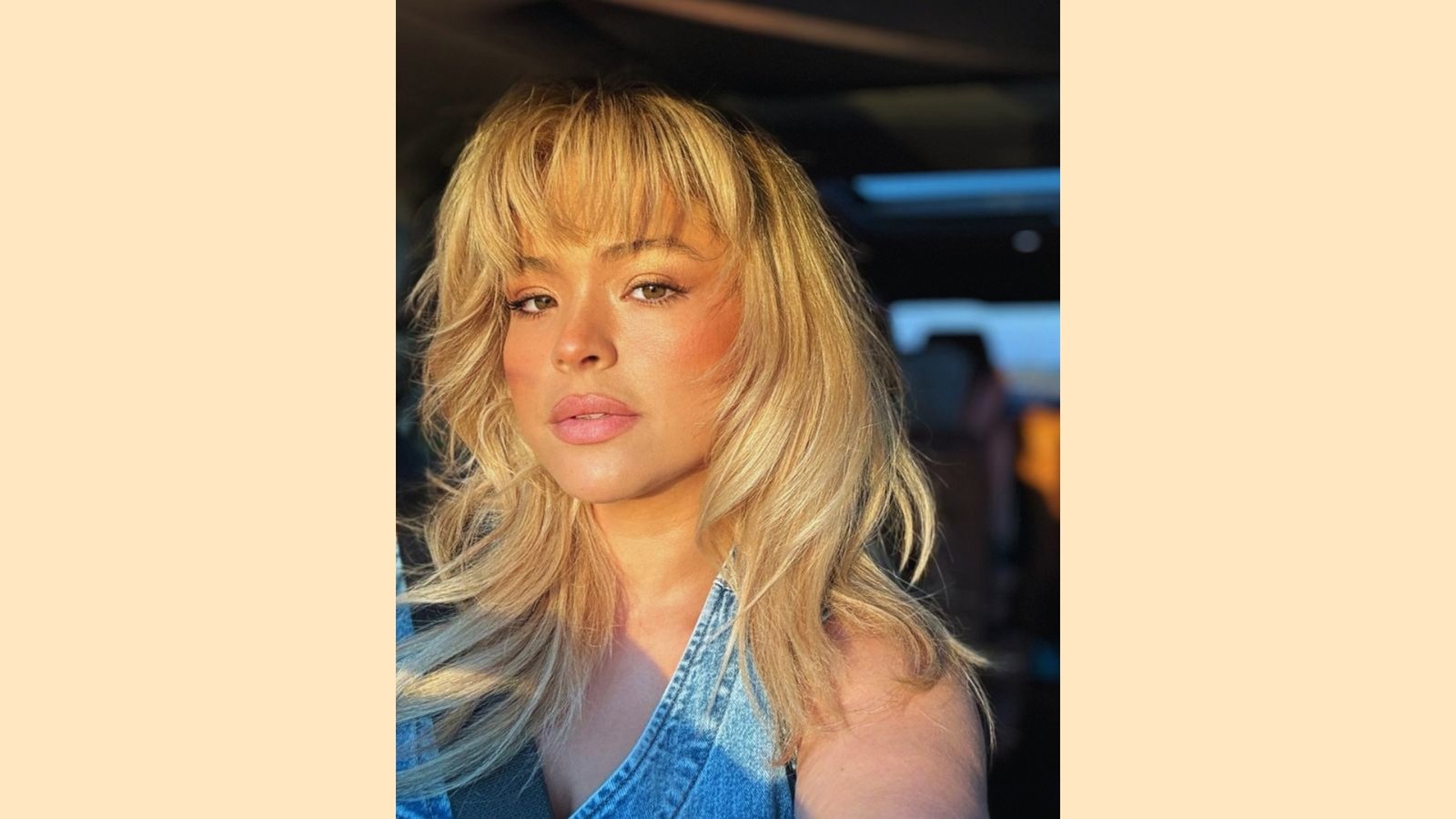 Long layered blonde hair with wispy curtain bangs and soft face-framing layers, tousled texture