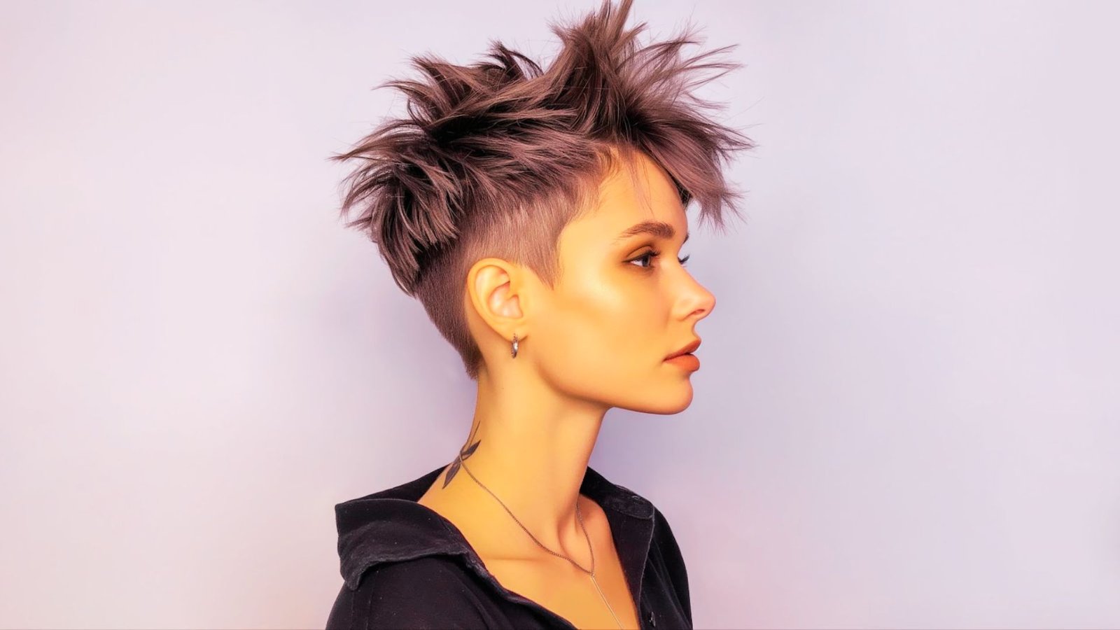 A woman with a short mohawk-influenced pixie cut featuring spiky hair, showcasing a bold and edgy hairstyle.