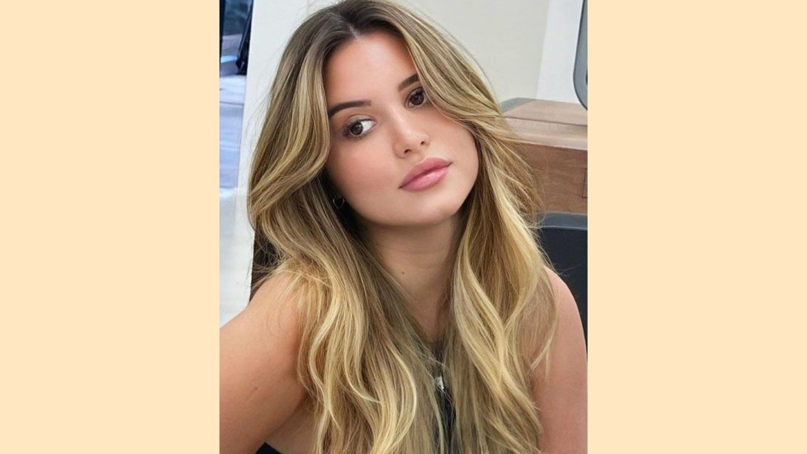 Wispy curtain bangs with long wavy layers and blonde balayage highlights
