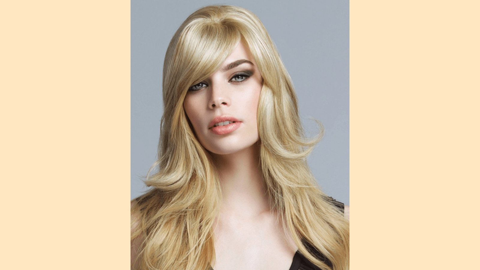 Long layered blonde hair with wispy side-swept curtain bangs and bouncy volume
