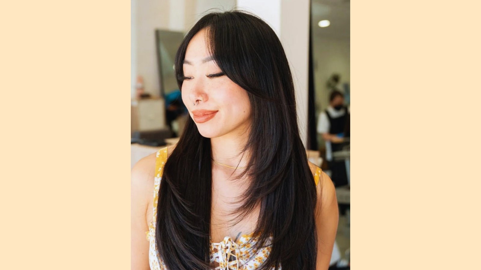 Long sleek straight black layered hair with wispy curtain bangs and soft feathered face-framing layers