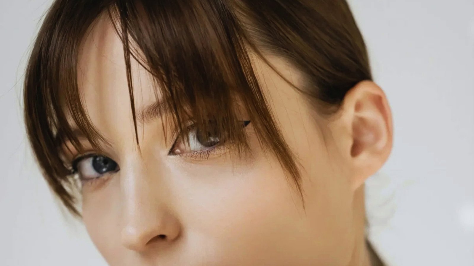Close-up of wispy see-through curtain bangs with soft texture on brunette hair