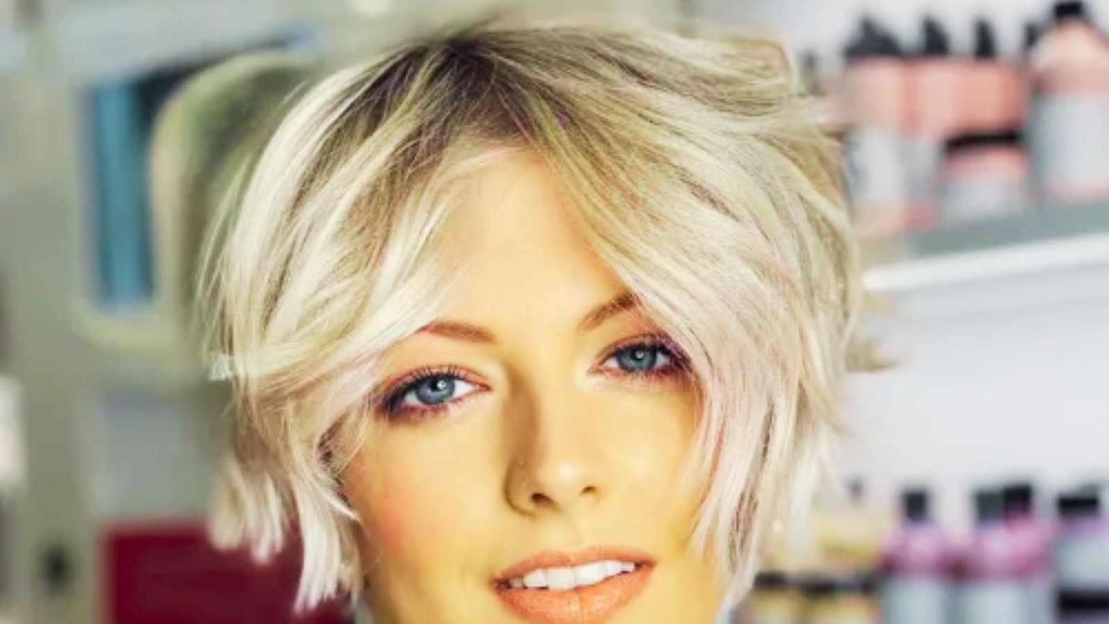 A woman with a choppy layered pixie cut and short blonde hair showcasing an edgy, messy hairstyle.