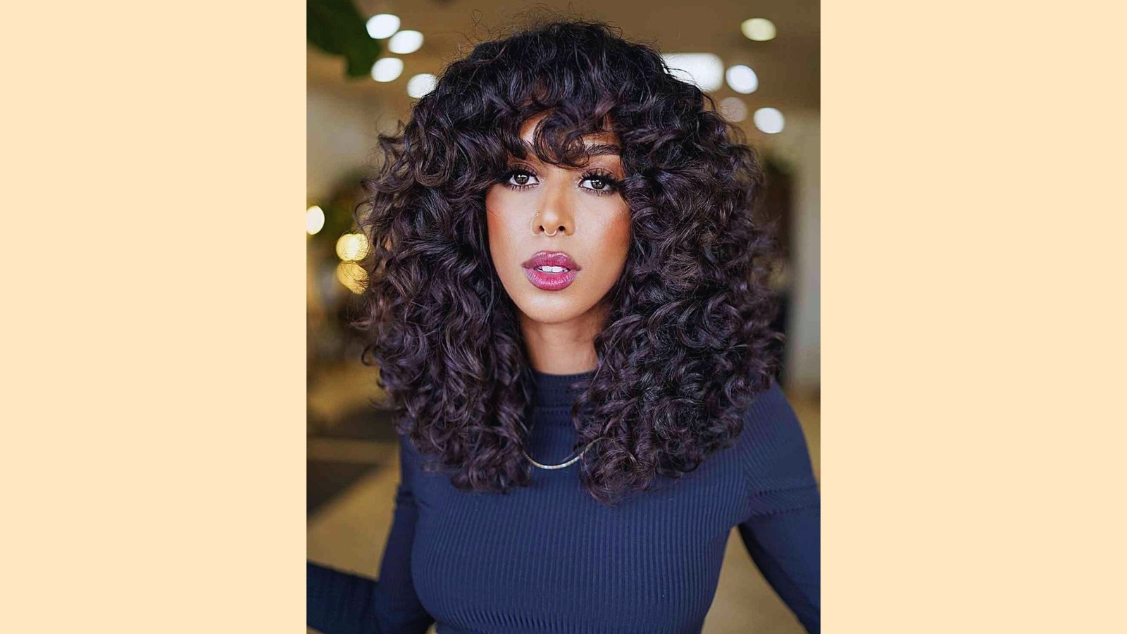 Medium length straight black hair with thick blunt bangs featuring wispy textured ends