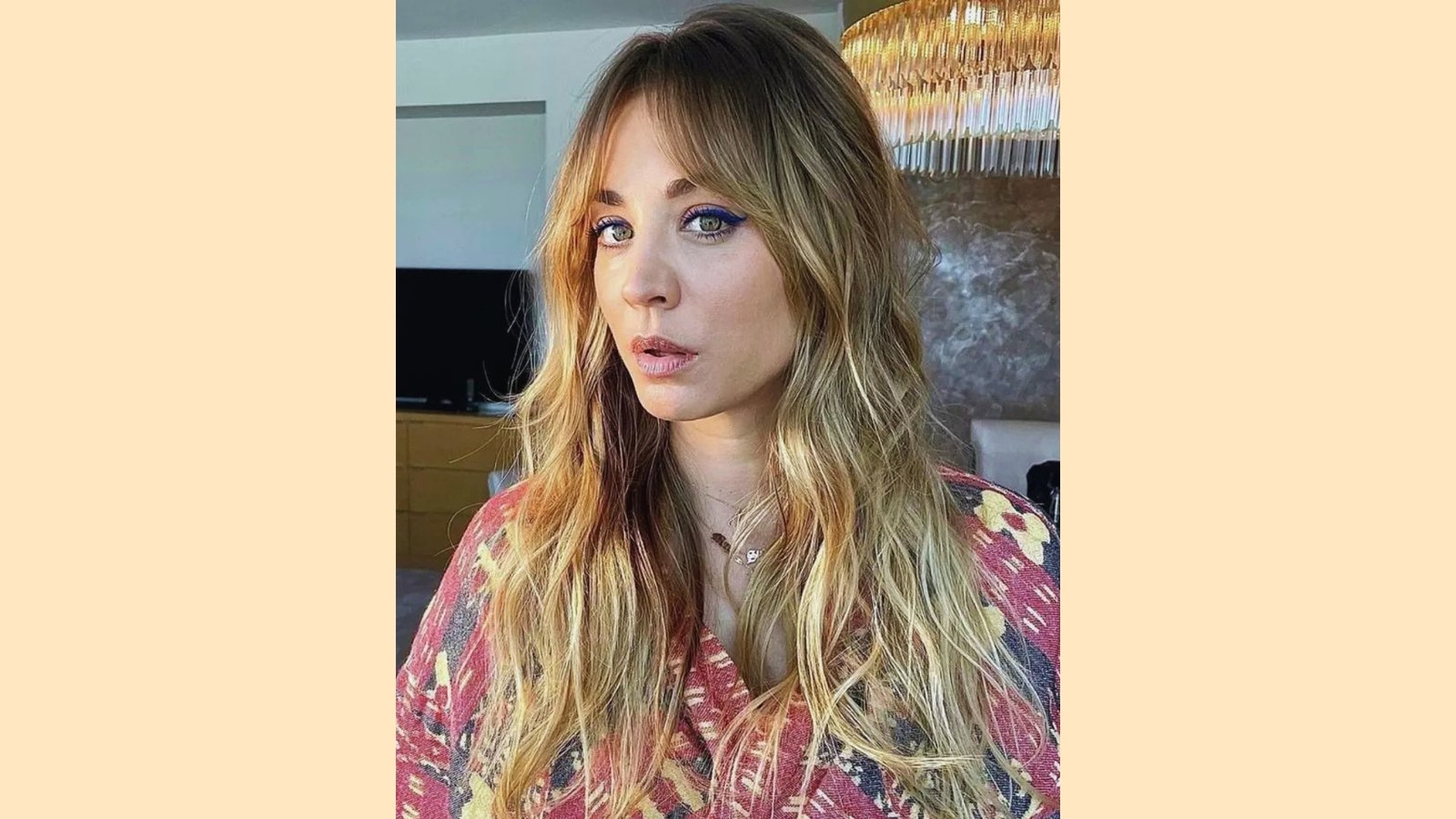 Long wavy blonde layered hair with wispy curtain bangs and soft face-framing pieces